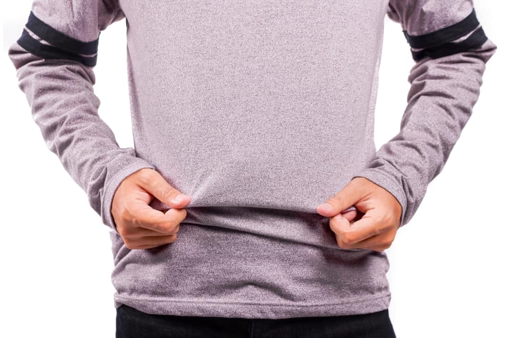 This is a close look at a man wearing a gray shirt made of stretch fabric.