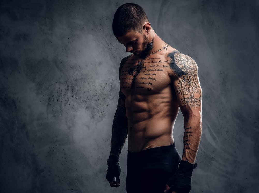 A man with multiple tattoos on his chest and arms.