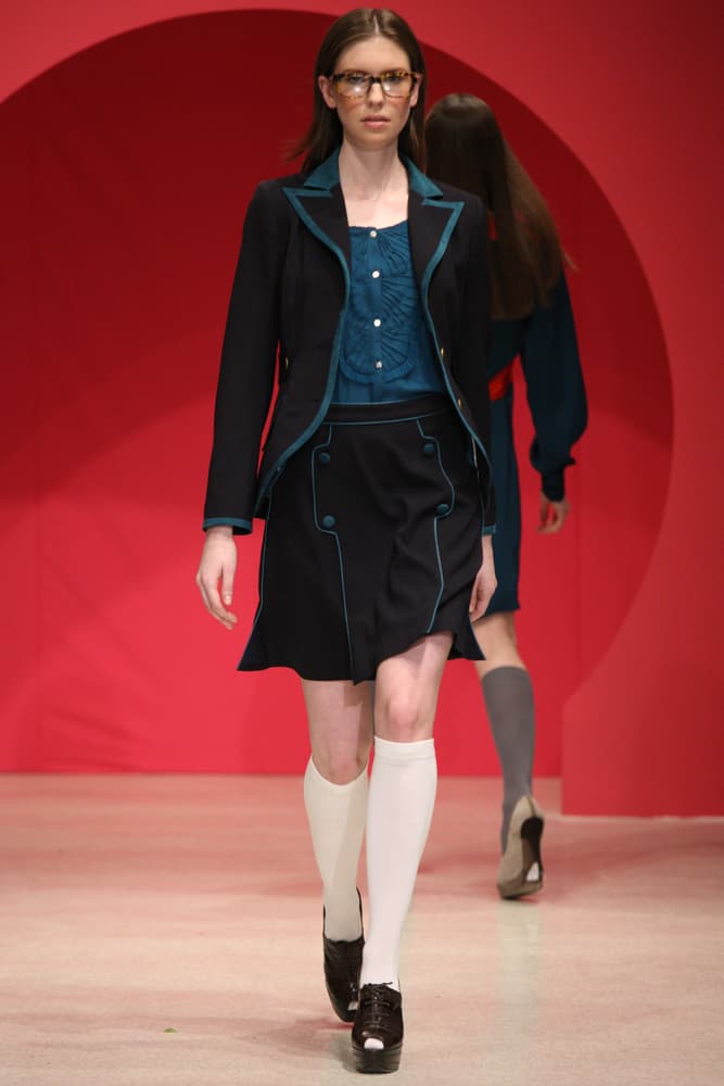 Model in preppy clothes walks the runway.