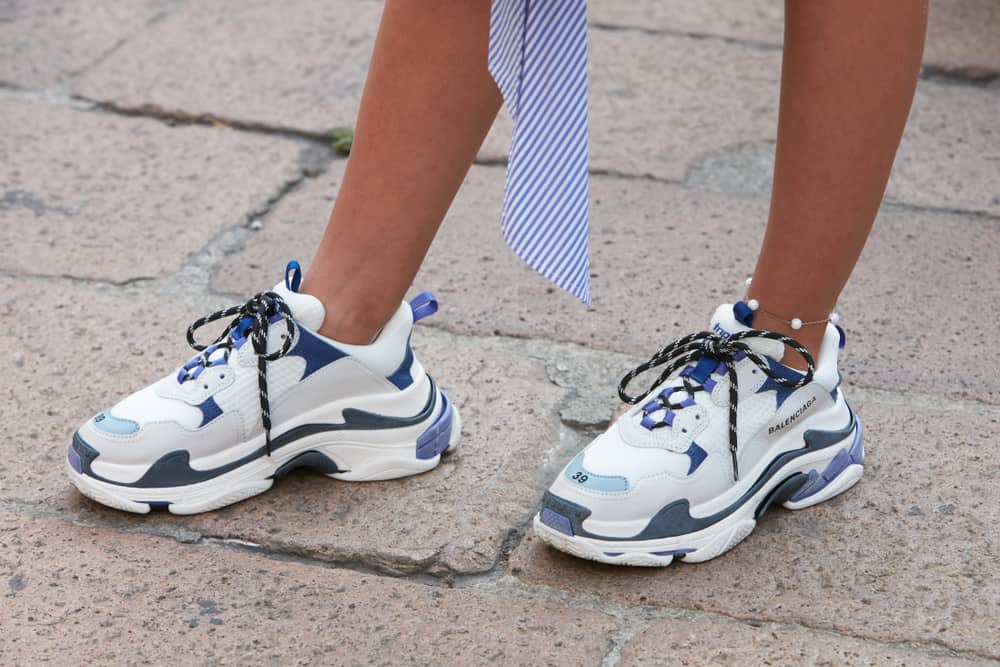 A woman wearing a pair of Balenciaga sneakers.