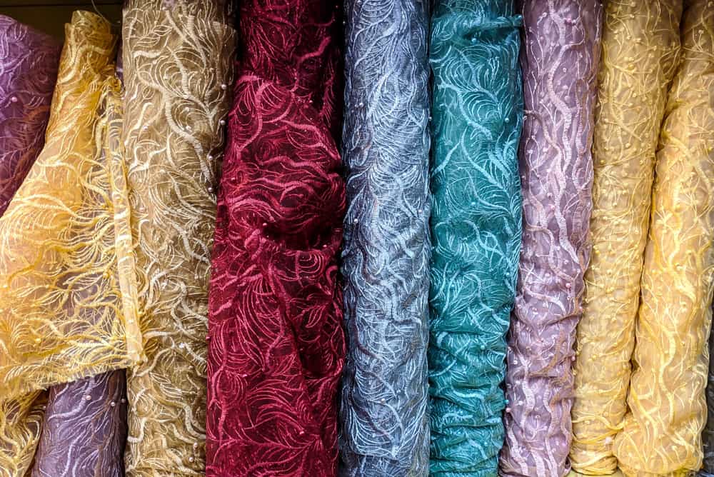 This is a close look at various colorful brocade fabrics on display.