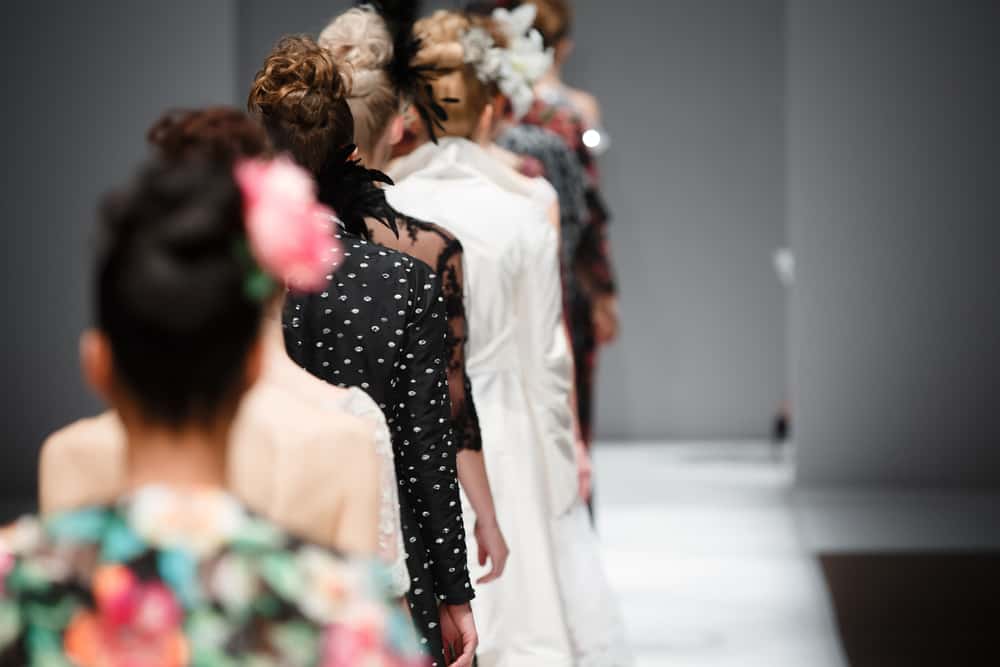 Models in various dresses walk the runway.