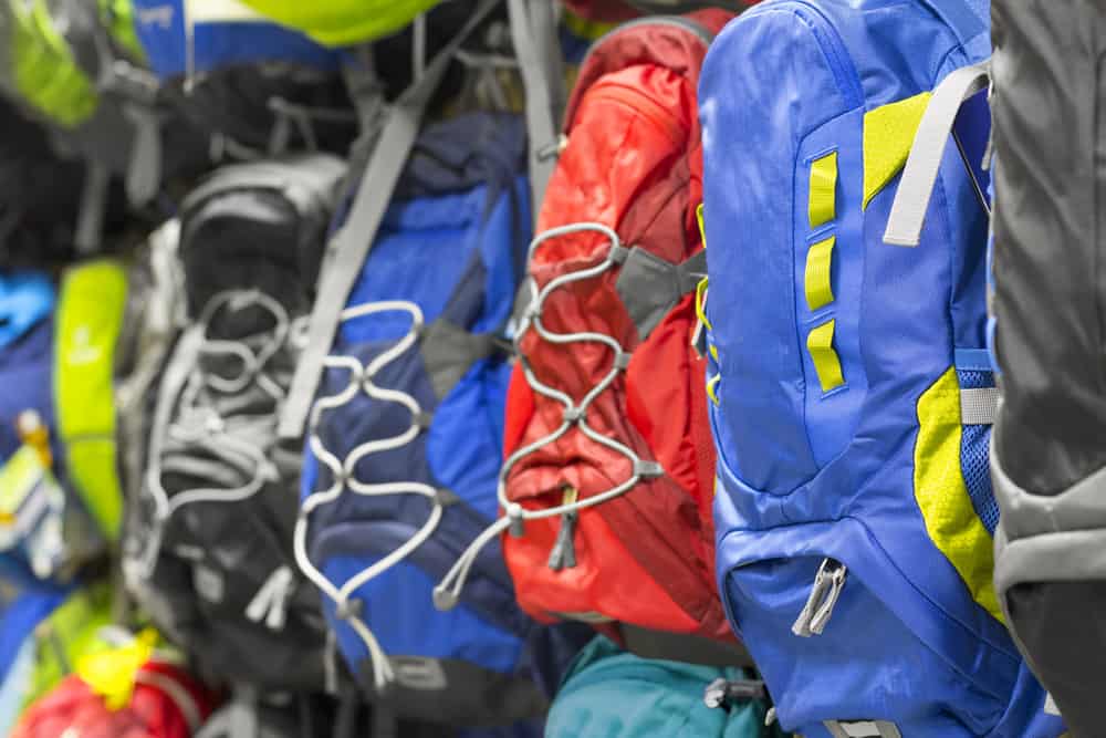 This is a close look at a bunch of colorful backpacks on display.