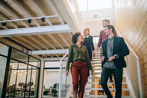 A group of coworkers walking down the office stairs.