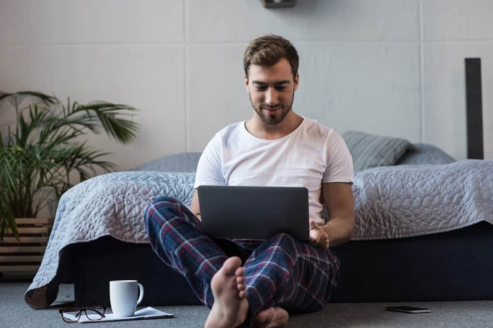 This is a close look at a man wearing lounge pants at the foot of the bed.