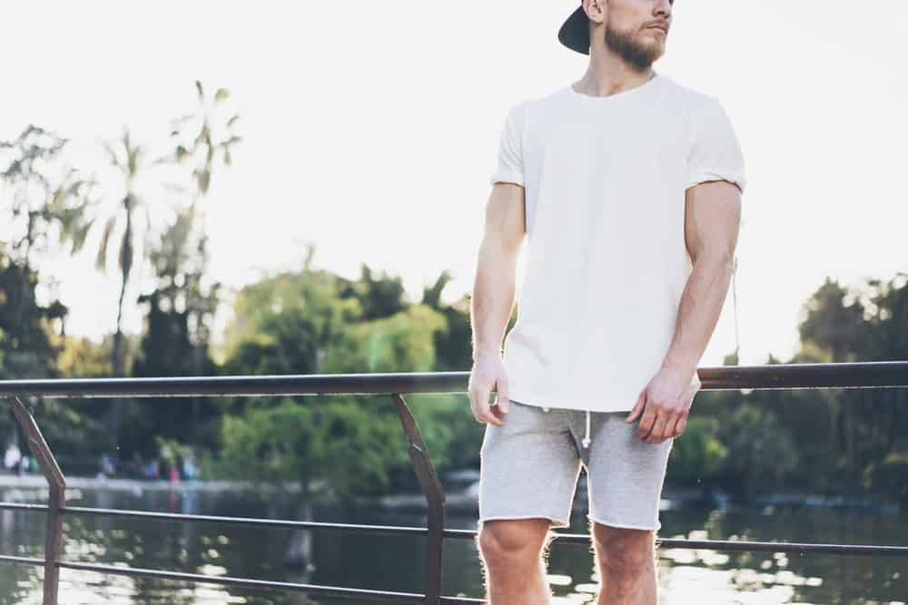 This is a close look at a man wearing a pair of gray drawstring shorts at the park.