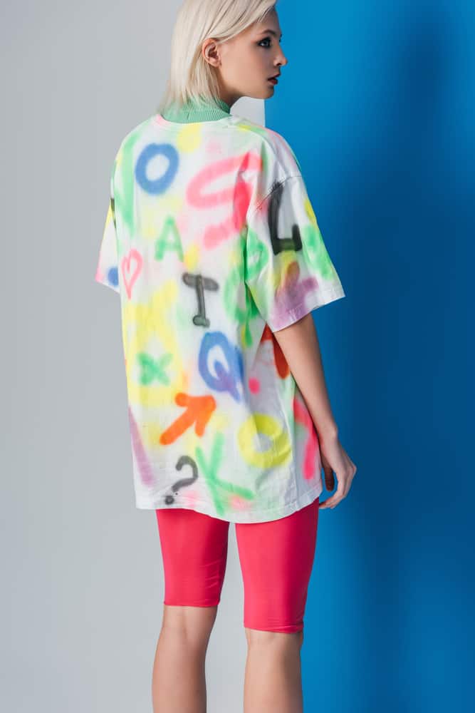 A woman wearing an oversized shirt and a pair of biking shorts.