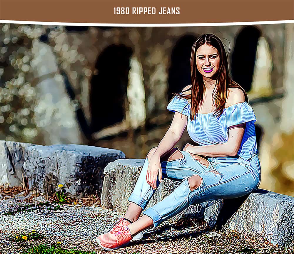 A woman wearing off-shoulders blouse and ripped jeans sits on a stone block.