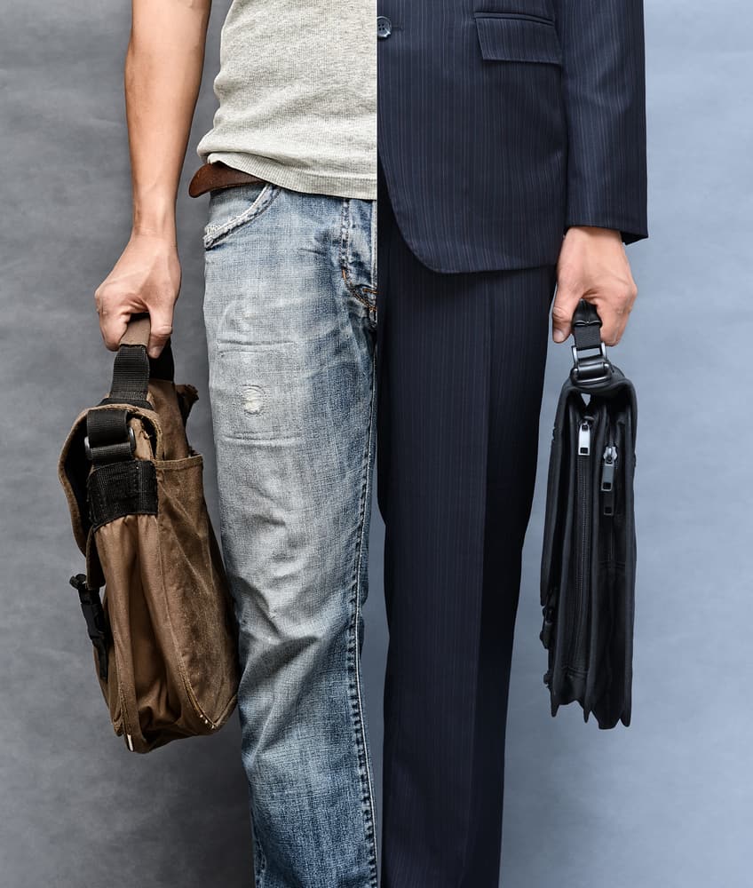 This is a close look at a man wearing half casual and half formal clothes.
