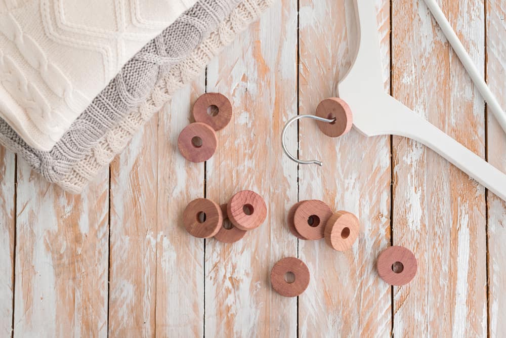This is a close look at a wooden clothes hanger with cedar rings.