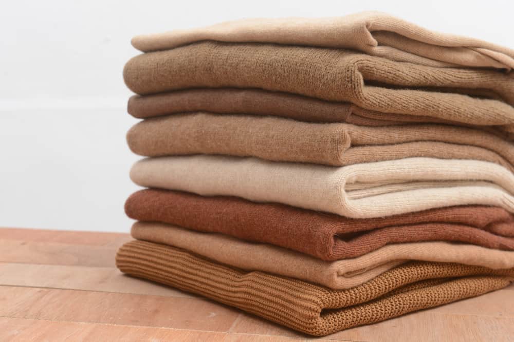 A look at a stack of folded knitted sweaters.