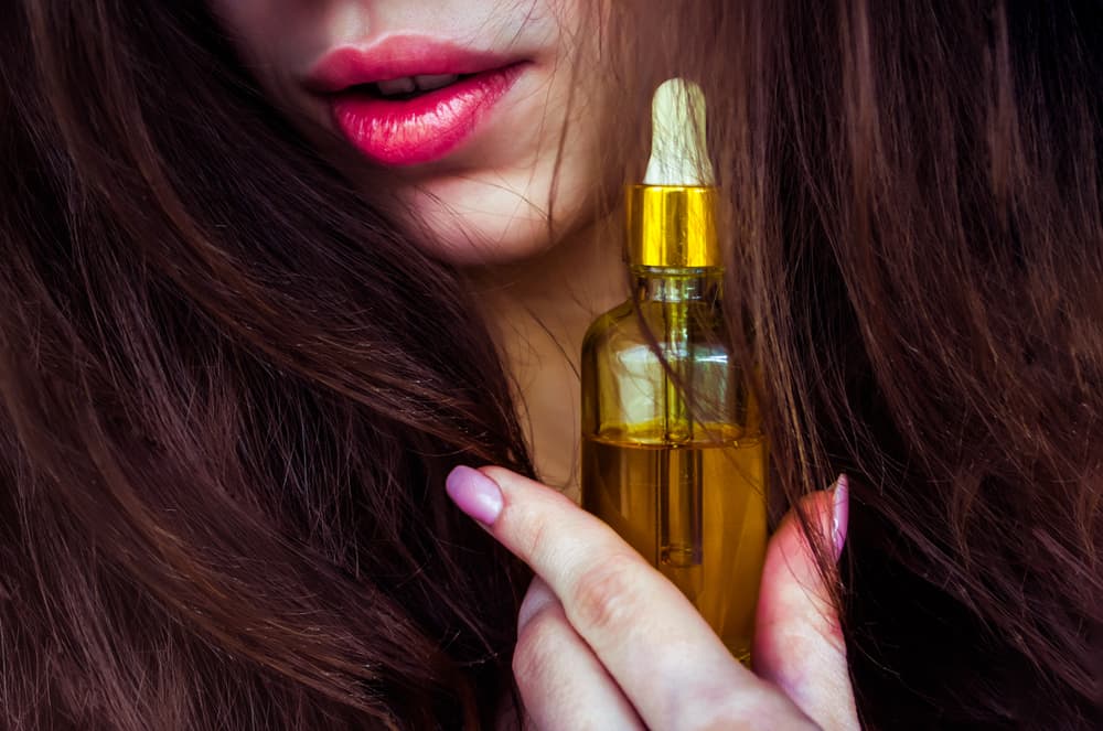 Woman holding castor oil.