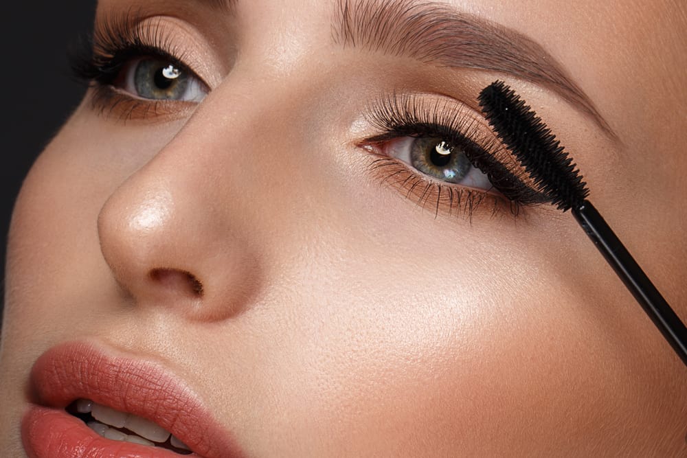 Woman applying mascara.
