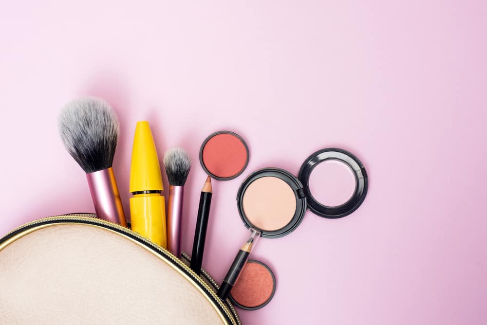 Makeup products spilling out of a cosmetics bag.