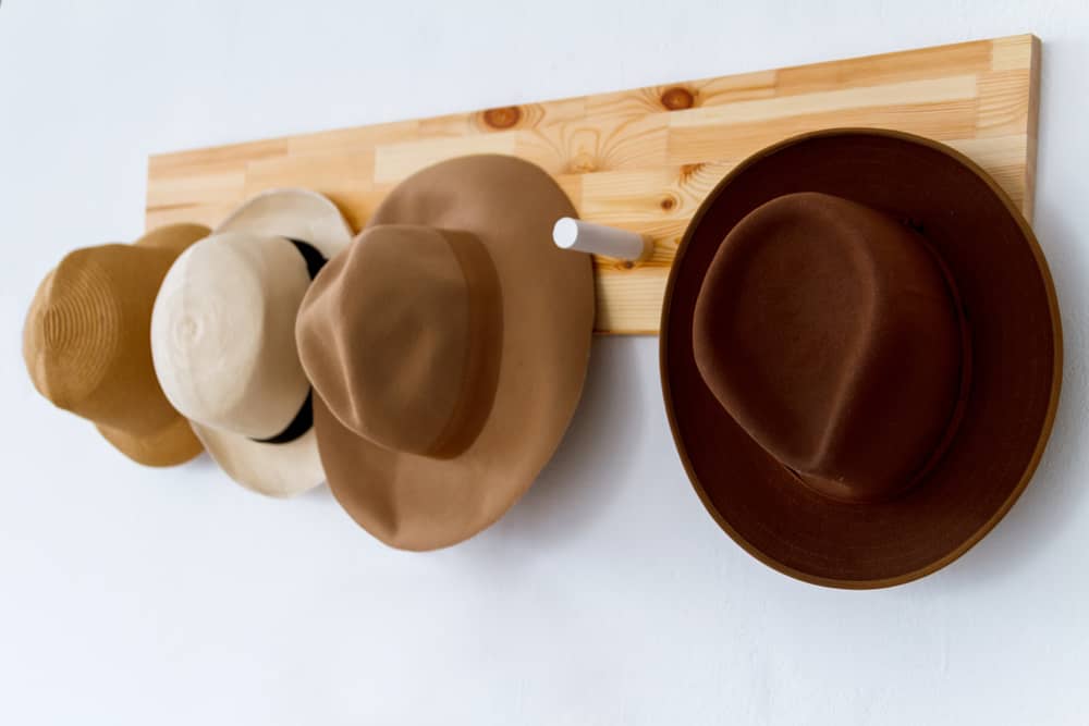 A close look at various hats hanging on a hanging rack.