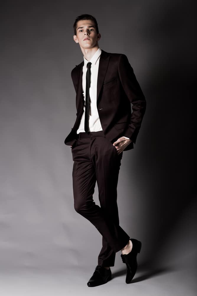 A man wearing a black suit with dress pants.