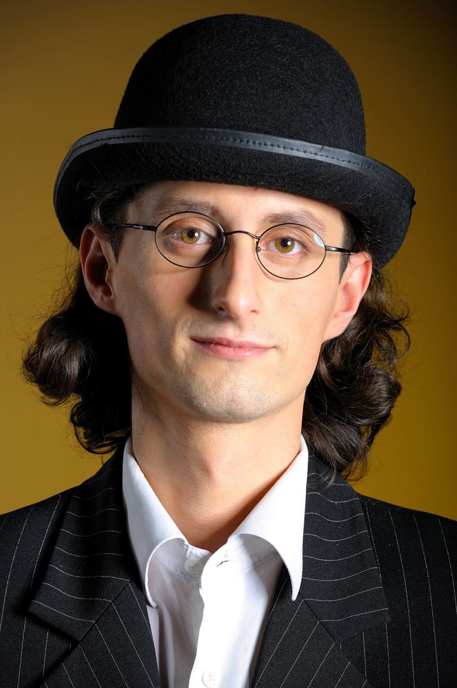 A man wearing a pin-striped suit and a bowler hat.