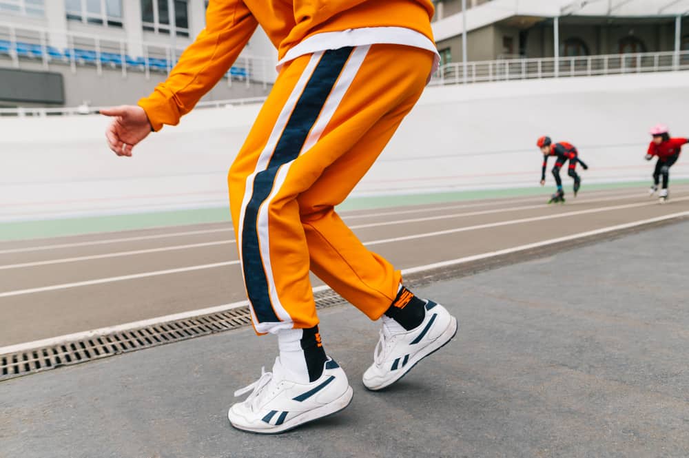 A man wearing a pair of yellow track pants.