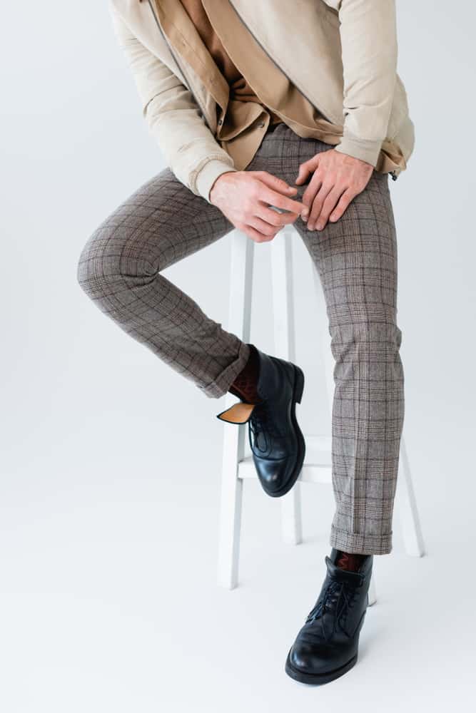 A man wearing a pair of gray checkered trousers.