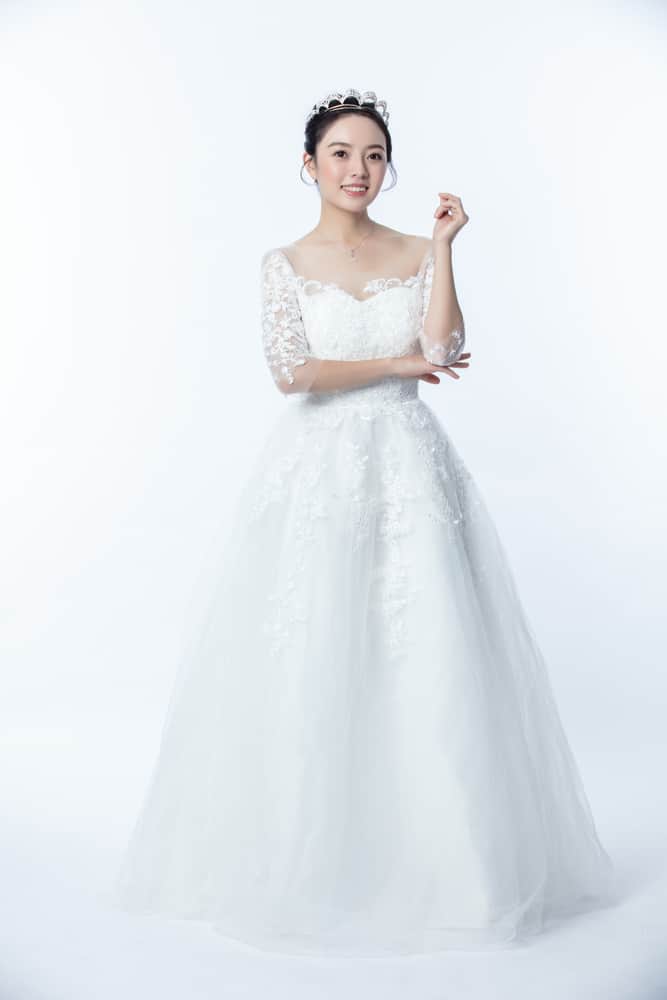 Bride wearing an embroidered wedding gown and a matching tiara.