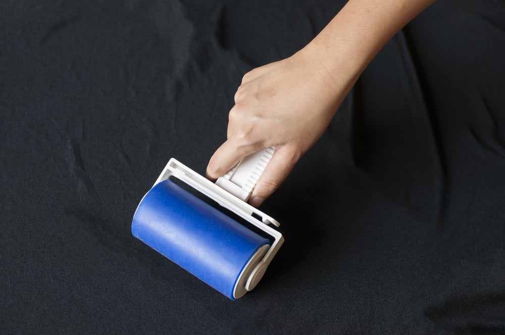 A lint roller on a black cloth.