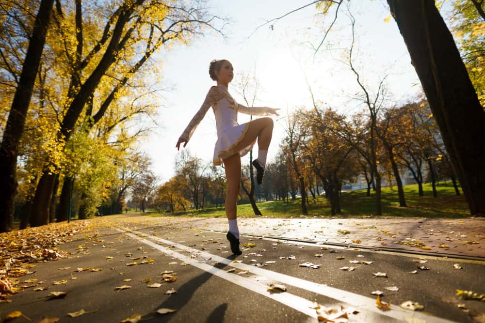 A girl dancing in a dress at the park.