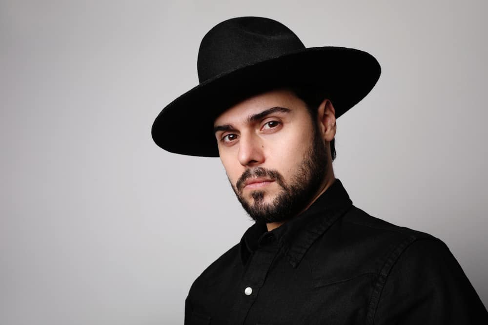 A man wearing a wide brim black fedora.