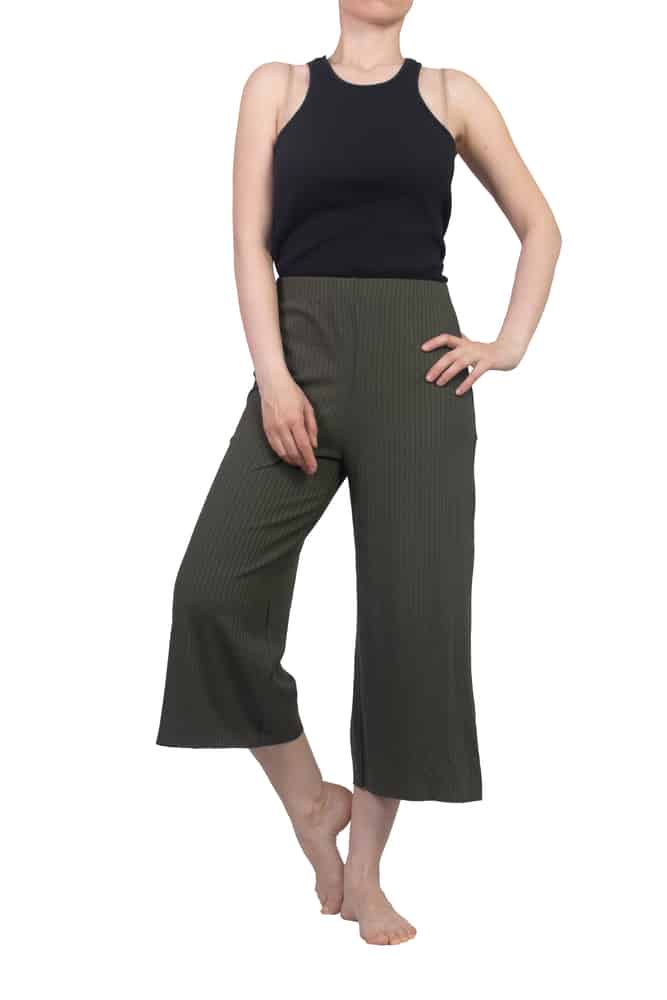 A woman wearing a pair of green capri pants.