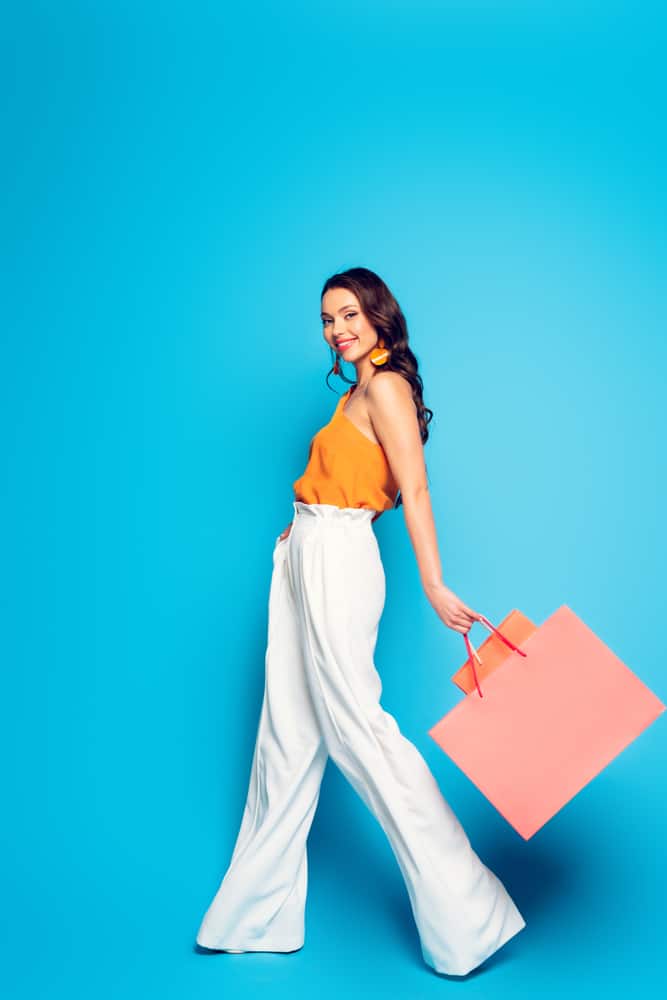 A woman wearing a pair of white loose palazzo pants.