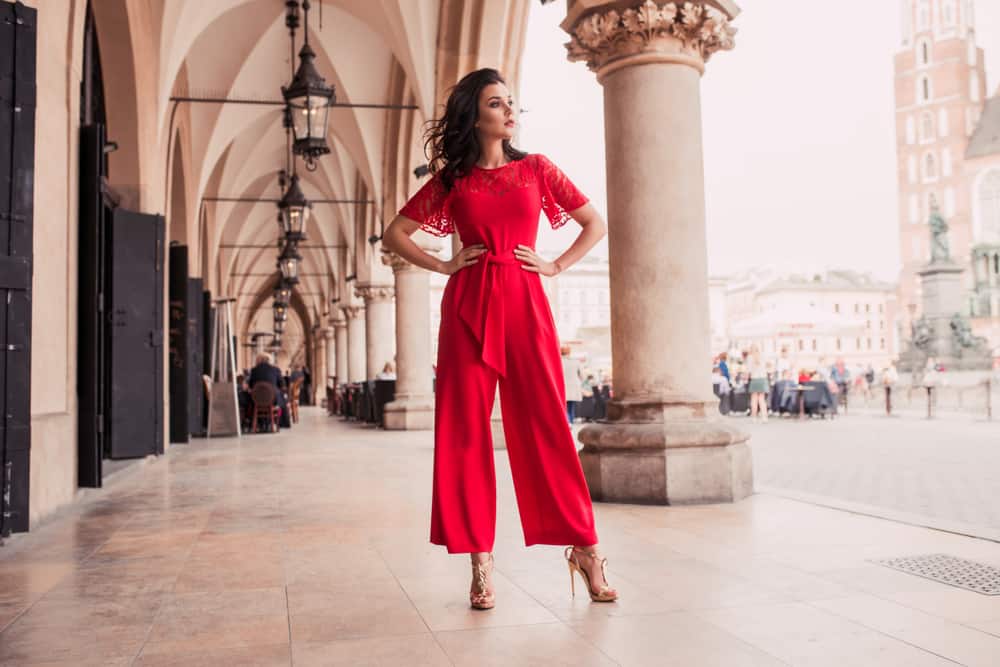 A woman wearing a bright pink jumpsuit with her high heels.