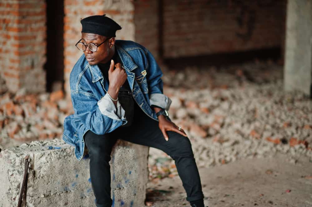 This is a man wearing a black beret with his denim jacket.