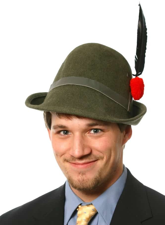 A man wearing a green alpini hat that has a tall feather on the side.