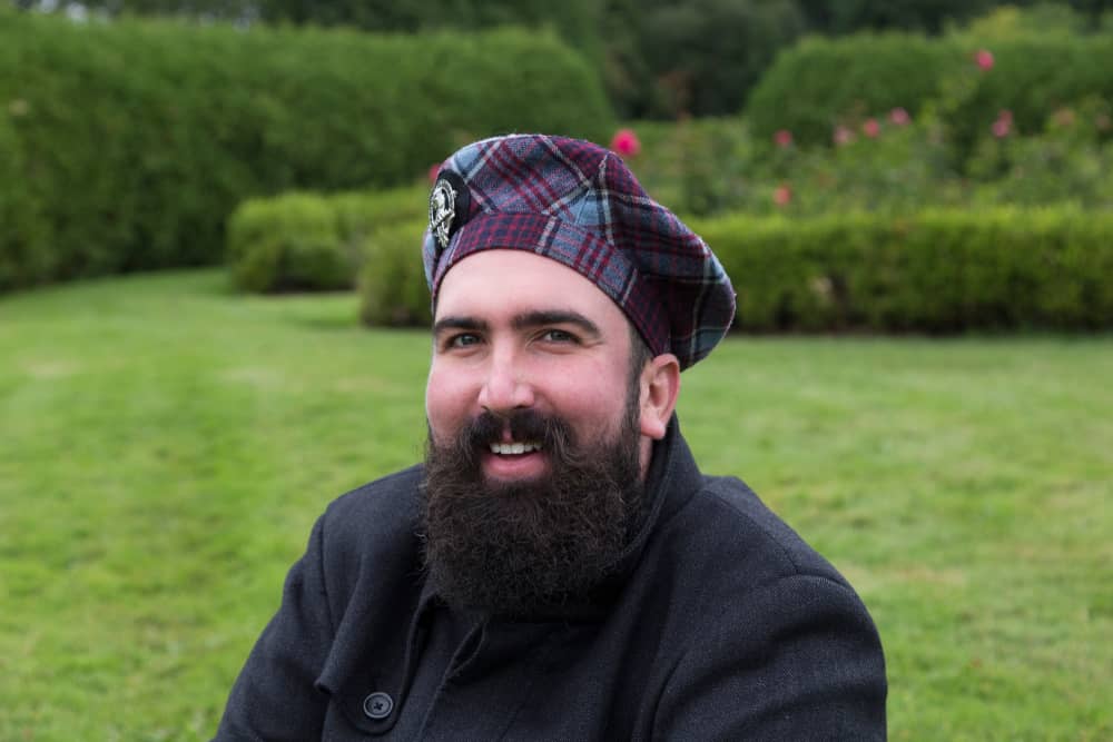 This is a man wearing a patterned traditional tam cap with his jacket.